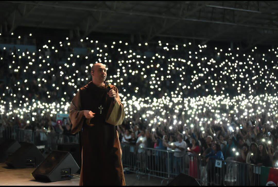 Frei Gilson durante apresentação religiosa diante de uma multidão de fiéis.